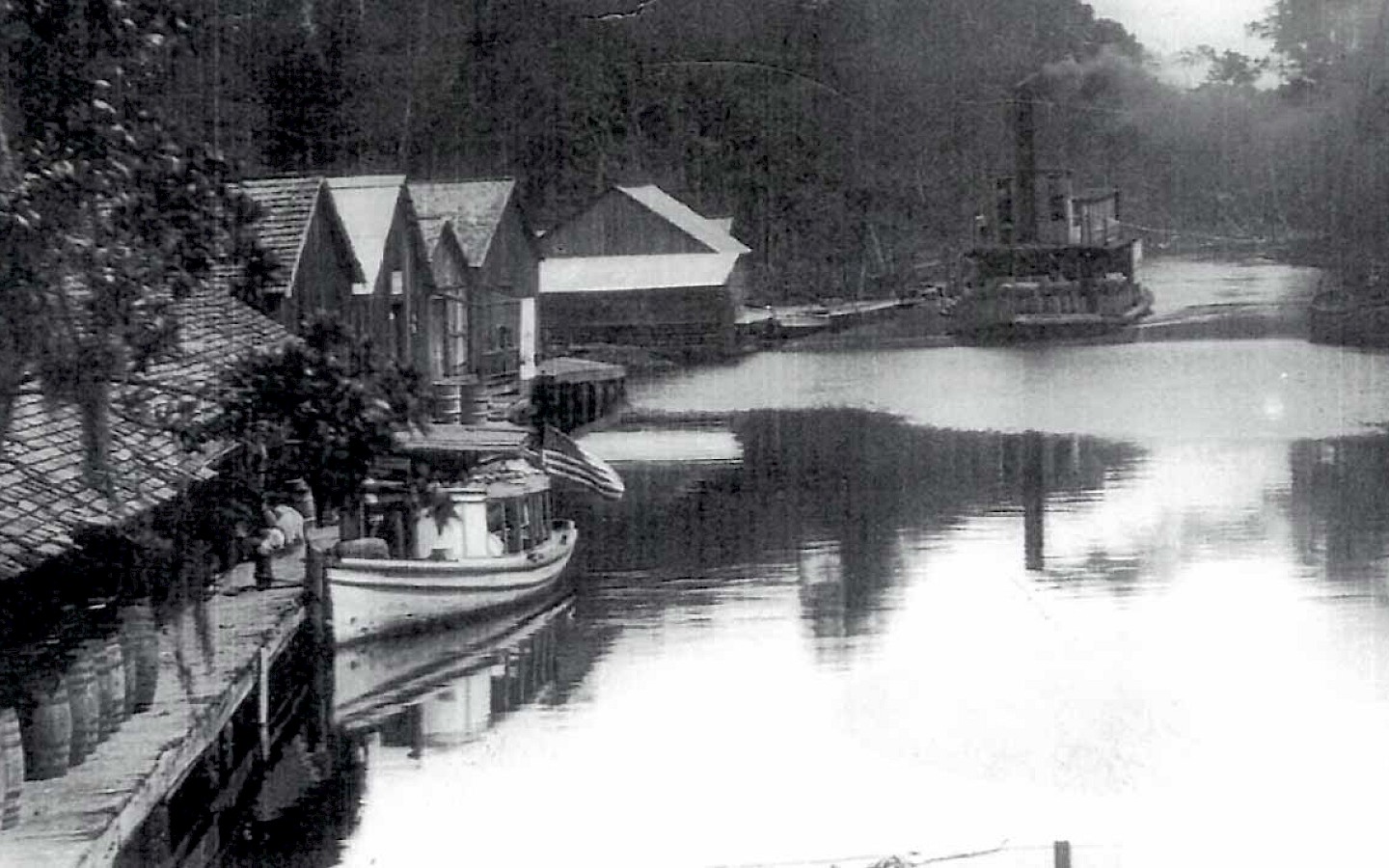 Photo taken in the early 1900s of a dock and wooden buildings next to the Choctawhatche River in Carryville, Florida